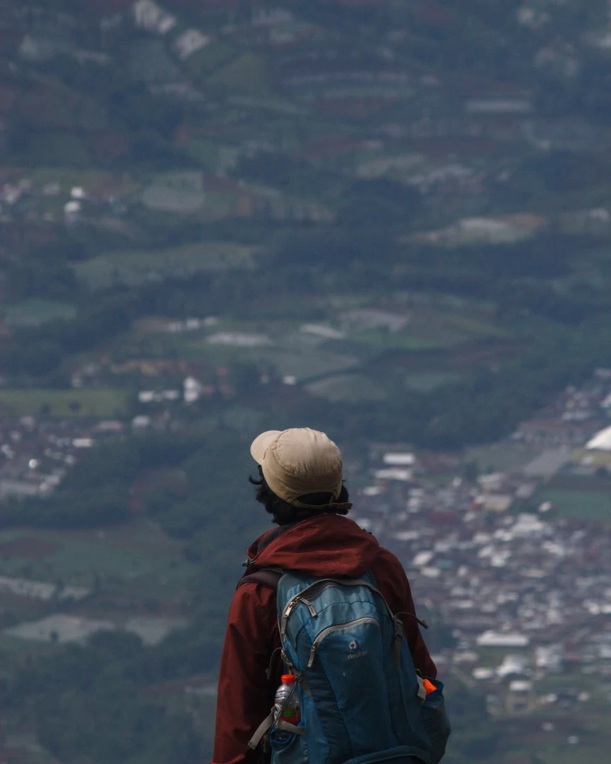 A traveler with a backpack looking out over a city